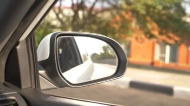 Arabayı yolda yaz aylarında geçerken dikiz aynası görüntüleyin. 4k, ağır çekim çekim
