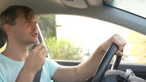 Ο άνθρωπος στο τιμόνι του αυτοκινήτου, τρώει Φαστ φουντ, ενώ το αυτοκίνητο κινείται. σε μια ηλιόλουστη μέρα του καλοκαιριού. 4k, αργή κίνηση — Αρχείο Βίντεο