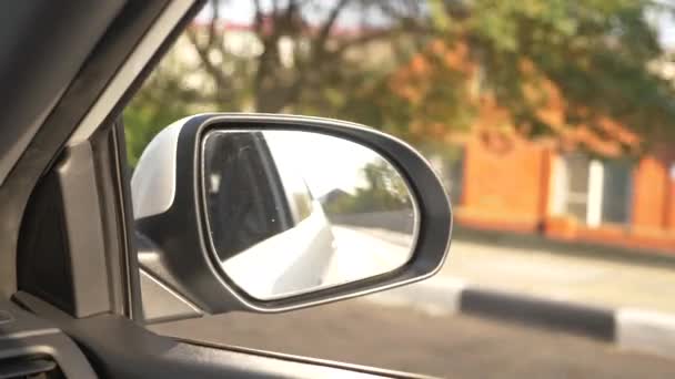 Vista al espejo retrovisor, cuando el coche pasa a lo largo de la carretera en el verano. 4k, disparo en cámara lenta — Vídeos de Stock