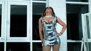 travesti taklitleri kavramı. yakışıklı genç kadın kıyafetlerini giymiş. bir profesyonel travestian sanatçı, teşkil etmektedir fotoğraf stüdyosu. klip çekim. 4k.