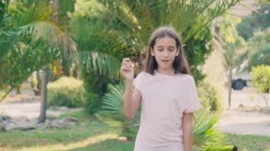 güzel genç kız parkta palmiye ağaçları bir arka plan üzerinde dans. 4k