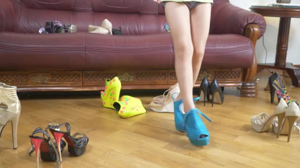 Una niña está jugando con zapatos de tacón alto. Las piernas de un niño pequeño en zapatos para adultos. chica con tacones altos. 4k, primer plano — Vídeo de stock