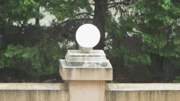 Lampadaire décoratif sous la pluie sur un fond de feuillage vert d'arbres. 4k, au ralenti — Video