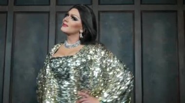 travesti taklitleri kavramı. yakışıklı genç kadın kıyafetlerini giymiş. bir profesyonel travestian sanatçı, teşkil etmektedir fotoğraf stüdyosu. klip çekim. 4k.