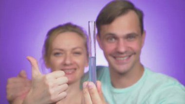 yakın çekim. Çift erkek ve kadın sarılma. renkli bir arka plan üzerinde elinde bir tüp ile. IVF kavramı. 4k, ağır çekim