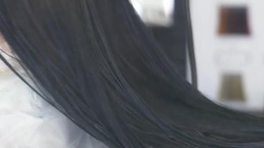 yakın çekim, profesyonel kuaför. saç için tonlama bir tonik esmer bir kızla saç boyama işlemi. Mavi renkli. saç kurutma makinesi ile saç kurutma