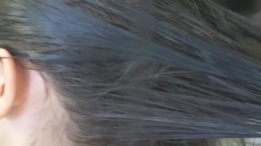 yakın çekim, profesyonel kuaför. saç için tonlama bir tonik esmer bir kızla saç boyama işlemi. Mavi renkli. saç kurutma makinesi ile saç kurutma