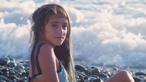 Schöne brünette Mädchen mit langen blauen Haaren, die sich im Wind entwickeln, vor dem Hintergrund von Meereswellen während eines Sturms. Freiheit, Kreativität, Geheimnis. 4k, Zeitlupe — Stockvideo