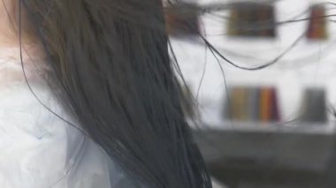 yakın çekim, profesyonel kuaför. saç için tonlama bir tonik esmer bir kızla saç boyama işlemi. Mavi renkli. saç kurutma makinesi ile saç kurutma