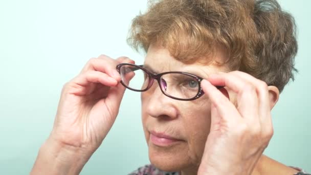 Hermosa mujer mayor con gafas. Visión. concepto de oftalmología. 4k, primer plano, cámara lenta — Vídeos de Stock