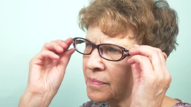 Beautiful senior woman wearing glasses. Vision. concept of ophthalmology. 4k, close-up, slow-motion — Stock Video