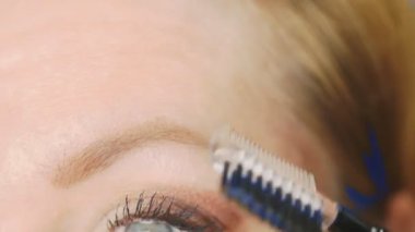 Süper yakın çekim, kadın kaş kalemi kaşları için boyar. 4k, ağır çekim. kadının ona makyaj yapması