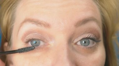 Genç kadının kendini evde makyaj yapması. ev hanımı maskara kirpik boya .