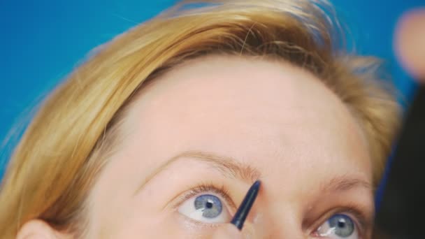 Супер крупным планом, женщина рисует карандаш для бровей. 4К, замедленная съемка. женщина делает макияж — стоковое видео