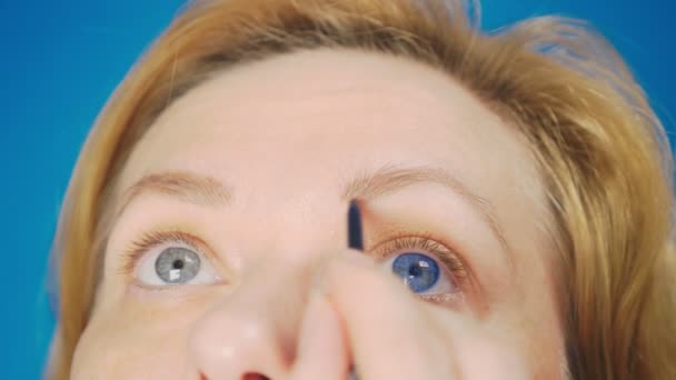 Super-Großaufnahme, Frau malt Augenbrauenstift für Augenbrauen. 4k, Zeitlupe. Frau beim Make-up — Stockvideo