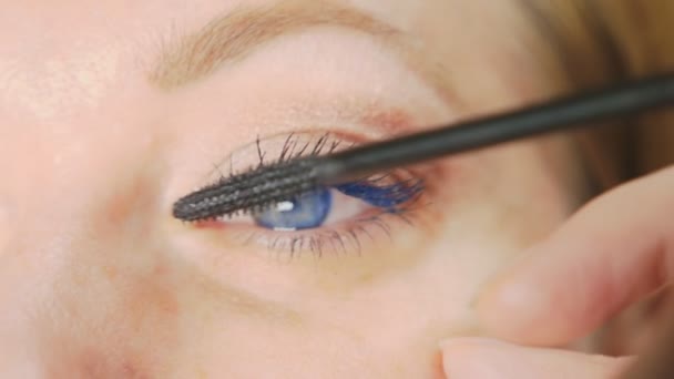 Ung kvinna gör makeup hemma själv. hemmafru mascara ögonfransar färgämne . — Stockvideo