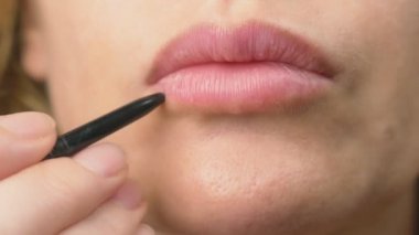 Süper yakın çekim, yavaş hareket, 4k. bir kadın dudaklarını dudaklarının için bir kalemle boyar. Dudak makyaj, dermatolojik hastalık dudaklar cilt üzerinde. Tilki tilki granül