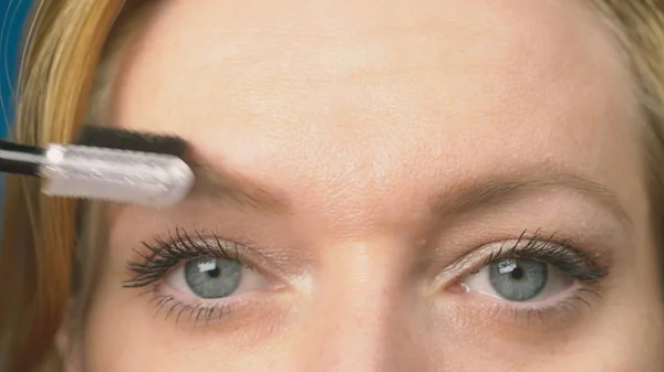 Super close-up, mulher pinta lápis de sobrancelha para sobrancelhas. mulher fazendo sua maquiagem — Fotografia de Stock