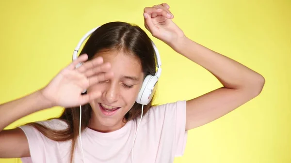 Tonårsflicka med hörlurar Lyssna på musik på färgbakgrund. närbild, — Stockfoto