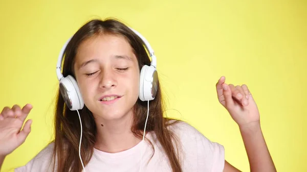 Девочка-подросток с наушниками, слушающая музыку на цветном фоне. макро , — стоковое фото