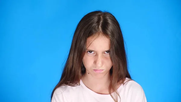 Close up. good looking sullen girl pouts lips, on blue background. Offended teen girl — Stock Photo, Image