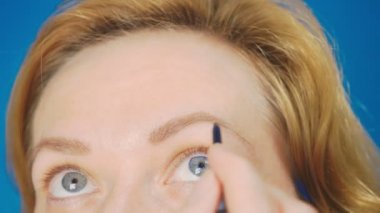 Süper yakın çekim, kadın kaş kalemi kaşları için boyar. 4k, ağır çekim. kadının ona makyaj yapması