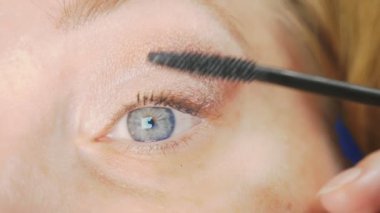 Genç kadının kendini evde makyaj yapması. ev hanımı maskara kirpik boya .