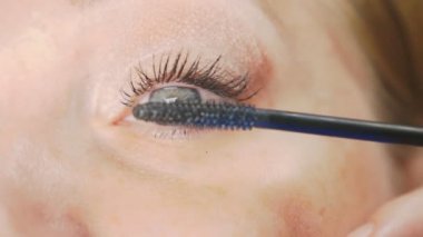 Genç kadının kendini evde makyaj yapması. ev hanımı maskara kirpik boya .