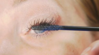 Genç kadının kendini evde makyaj yapması. ev hanımı maskara kirpik boya .