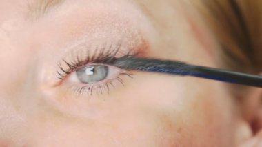 Genç kadının kendini evde makyaj yapması. ev hanımı maskara kirpik boya .