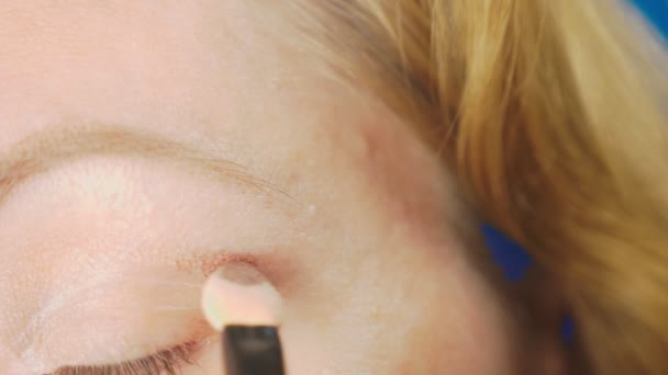Super close-up, uma mulher fazendo a maquiagem dos olhos, pinta a pálpebra com sombras. 4k, câmera lenta — Vídeo de Stock