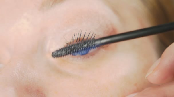 Ung kvinna gör makeup hemma själv. hemmafru mascara ögonfransar färgämne . — Stockvideo