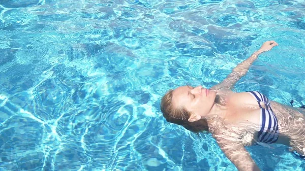 穿着泳衣的年轻漂亮女子躺在外面的水里. — 图库照片