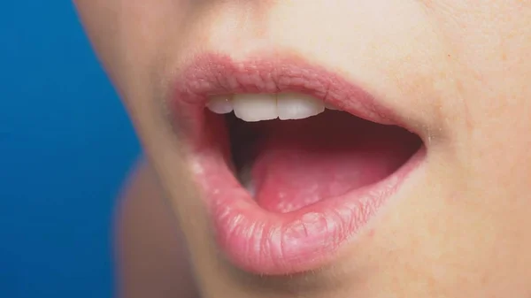 Close-up, lábios femininos sem maquiagem, em um fundo azul. a emoção da surpresa . — Fotografia de Stock