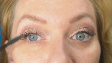 Genç kadının kendini evde makyaj yapması. ev hanımı maskara kirpik boya .