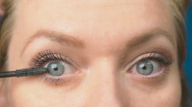 Genç kadının kendini evde makyaj yapması. ev hanımı maskara kirpik boya .