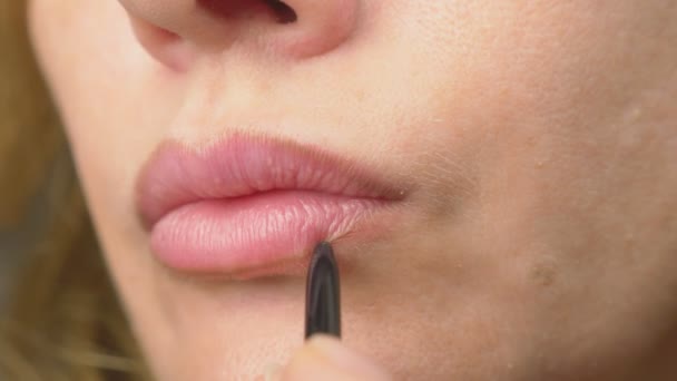 Super primer plano, cámara lenta, 4k. una mujer se pinta los labios con un lápiz para los labios. maquillaje labial, enfermedad dermatológica en la piel de los labios. Fox Zorros gránulos — Vídeo de stock