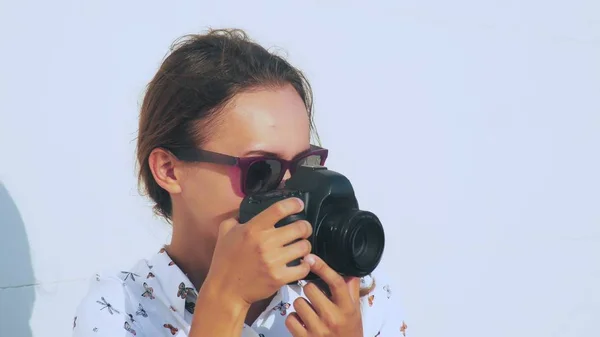 La chica fotógrafa dispara al modelo al aire libre, de cerca, la lente de la cámara . —  Fotos de Stock