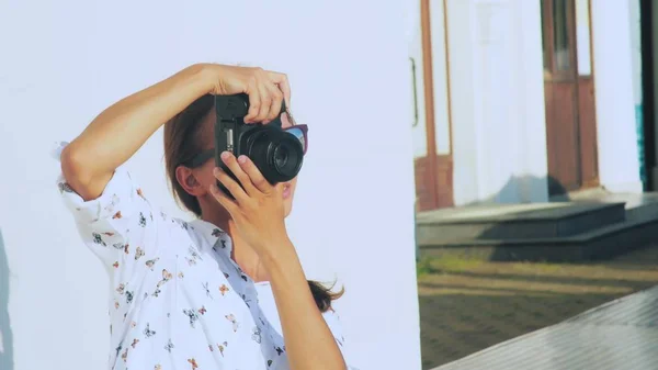 La chica fotógrafa dispara al modelo al aire libre, de cerca, la lente de la cámara . —  Fotos de Stock