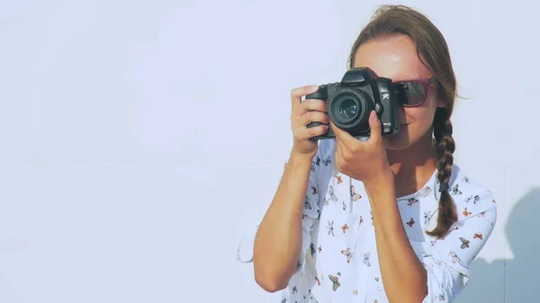 La chica fotógrafa dispara al modelo al aire libre, de cerca, la lente de la cámara . — Foto de Stock