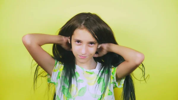 Het concept van haar verven, toning, kleuren haar. het meisje op een gele achtergrond, gelukkig toont haar lange haren, geschilderd in blauw — Stockfoto