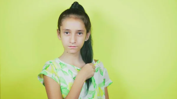 O conceito de tingir o cabelo, tonificação, colorir o cabelo. a menina em um fundo amarelo, alegremente demonstra seu cabelo longo, pintado em azul — Fotografia de Stock