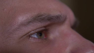 Yakın çekim, bir insan gözü mans. adam yakından video izlerken Tv ekranında görünüyor.