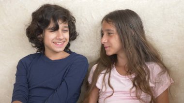Portrait of adorable brother and sister, teenagers smiling and laughing with funny expression on their faces. Family happiness and relations. clipart