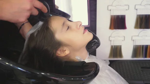 Zbliżenie, Profesjonalny salon fryzjerski. Proces malowania włosy brunetka dziewczynka z tonowania tonik do włosów. mycie głowy — Zdjęcie stockowe