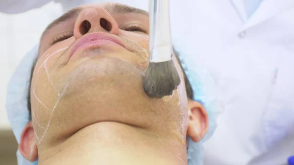 Lifting facial no quirúrgico. SMAS levantando ultrasonidos. El proceso de rejuvenecimiento. Cosmetología de hardware. contorno de cara de plástico. manos de un dermatólogo médico hacer un hombre un ultrasonido lifting facial — Foto de Stock