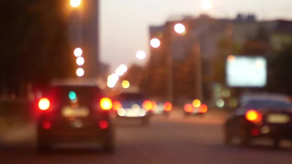 Driving at night. View the windshield and blurred cars in the city. window of the front car with a blurred city traffic on city streets. — Stock Photo, Image