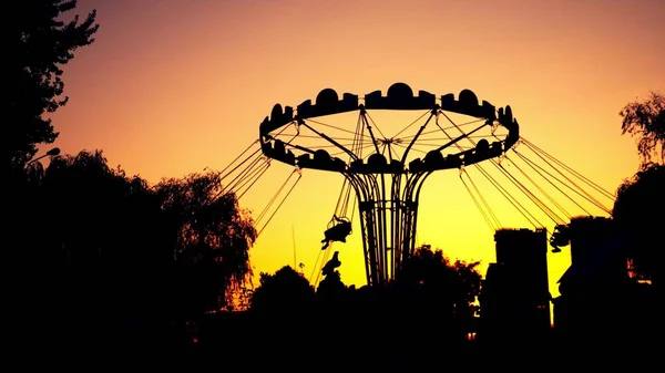 Die Silhouette des Karussells dreht sich. vor dem Hintergrund des Sonnenuntergangs. — Stockfoto