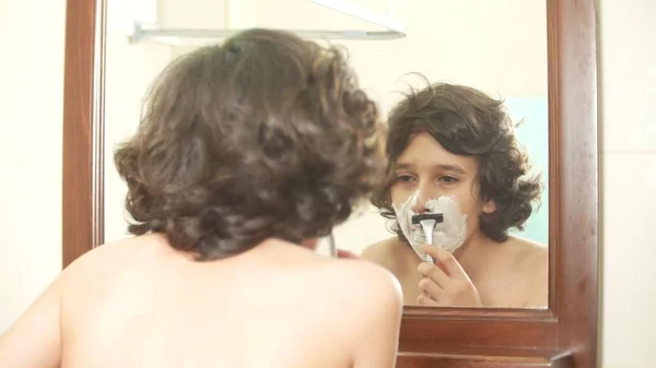 Tiener scheert eerst met tiener toepassen scheerschuim, huidverzorging, crème, gezicht — Stockfoto