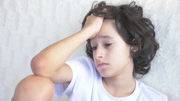 Retrato de um adolescente triste cansado que se senta no sofá . — Fotografia de Stock